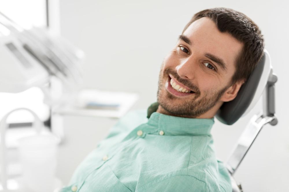 man smiling after getting an infected tooth extracted